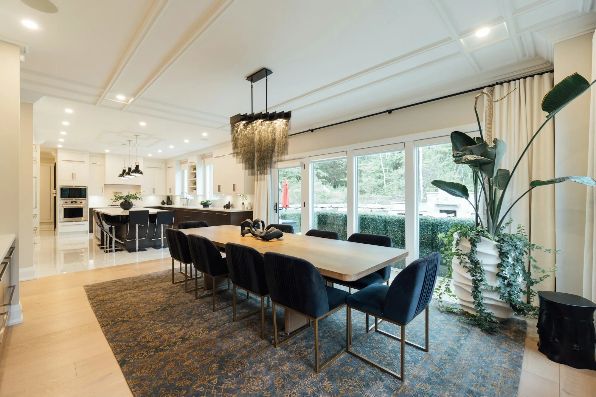 Open dining and kitchen area with a long table and large windows