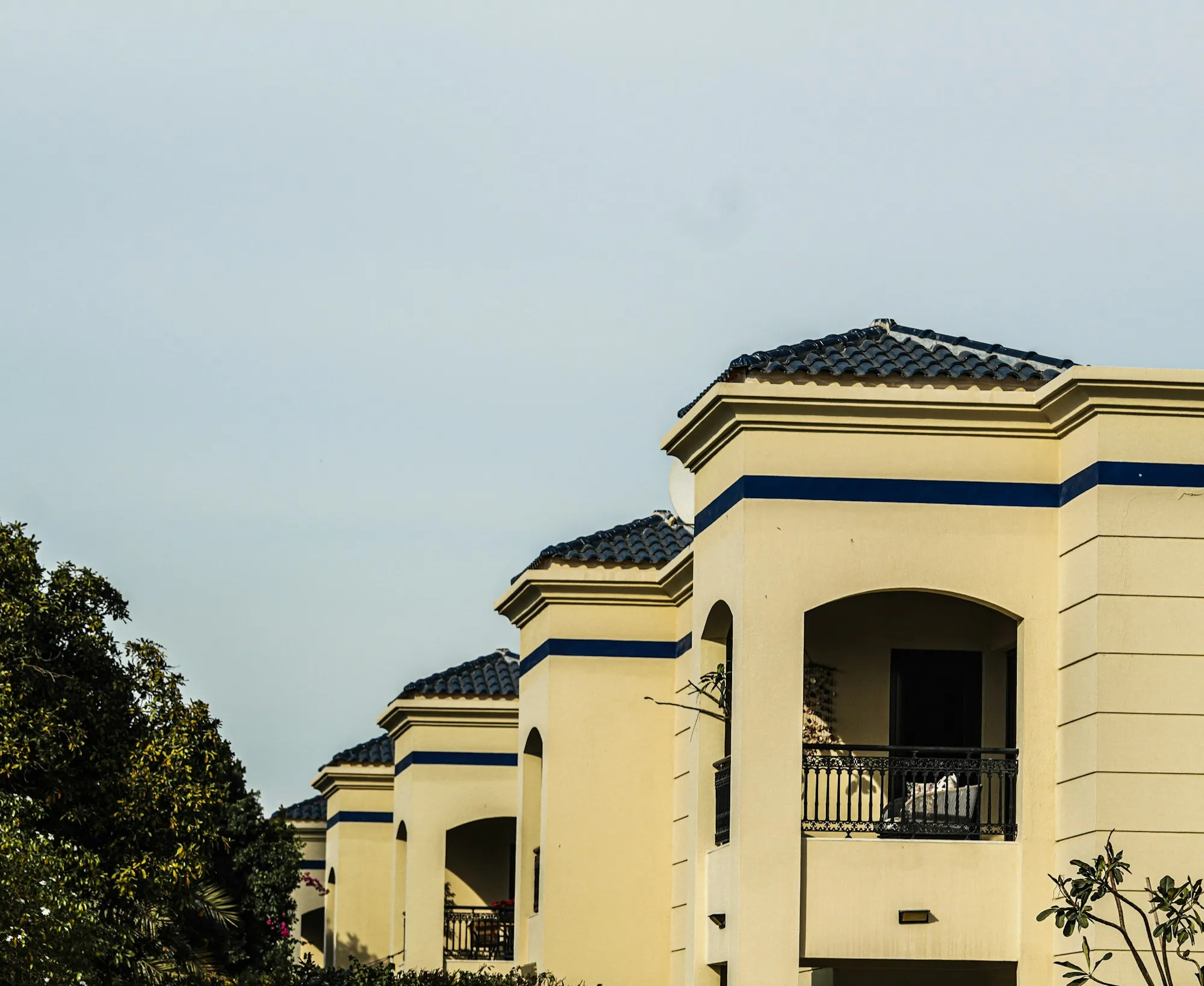 Cream stucco townhomes with tile roofs and balconies